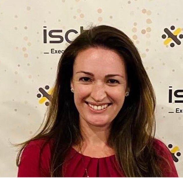 Portrait of a smiling woman against a backdrop featuring repeating corporate logos